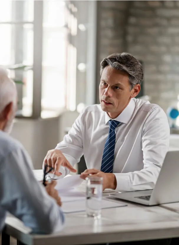 Mid Adult Insurance Agent With Mature Couple Analyzing Financial Reports Communicating During Meeting Office